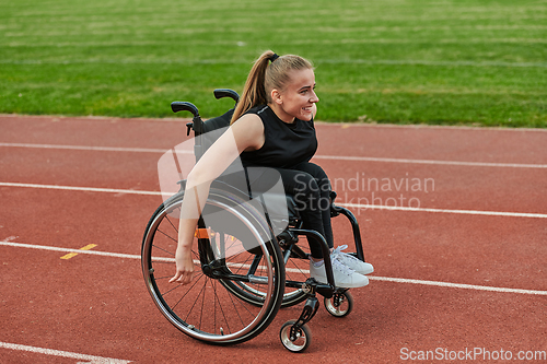 Image of A woman with disablity driving a wheelchair on a track while preparing for the Paralympic Games