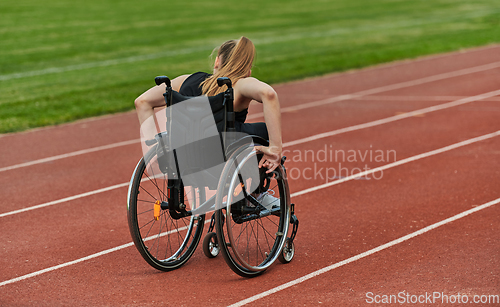 Image of A woman with disablity driving a wheelchair on a track while preparing for the Paralympic Games