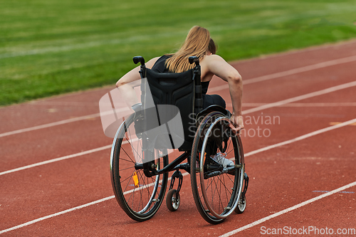 Image of A woman with disablity driving a wheelchair on a track while preparing for the Paralympic Games