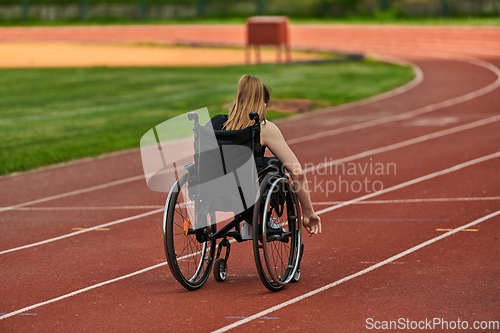 Image of A woman with disablity driving a wheelchair on a track while preparing for the Paralympic Games