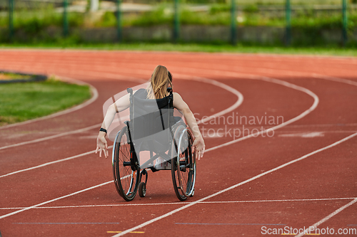 Image of A woman with disablity driving a wheelchair on a track while preparing for the Paralympic Games