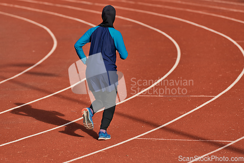 Image of A muslim woman in a burqa sports muslim clothes running on a marathon course and preparing for upcoming competitions