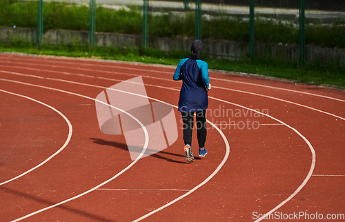 Image of A muslim woman in a burqa sports muslim clothes running on a marathon course and preparing for upcoming competitions