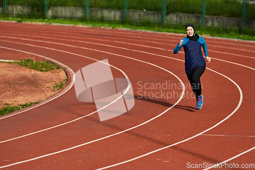 Image of A muslim woman in a burqa sports muslim clothes running on a marathon course and preparing for upcoming competitions