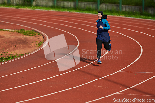 Image of A muslim woman in a burqa sports muslim clothes running on a marathon course and preparing for upcoming competitions