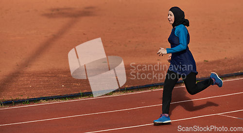 Image of A muslim woman in a burqa sports muslim clothes running on a marathon course and preparing for upcoming competitions