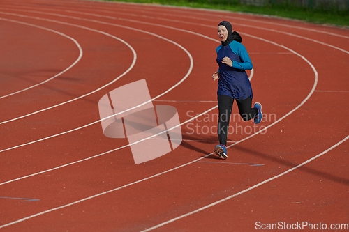 Image of A muslim woman in a burqa sports muslim clothes running on a marathon course and preparing for upcoming competitions