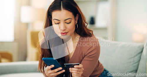 Image of Woman, credit card and phone for e commerce, online shopping and fintech bank app on house or home living room sofa. Smile, happy and relax customer on technology Vietnamese ecommerce retail website