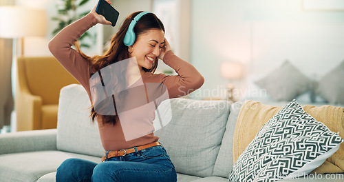 Image of Phone, dancing and woman streaming music via headphones to relax with freedom on the weekend at home. Dance, excited and happy girl enjoys listening to a radio song or audio on an online subscription