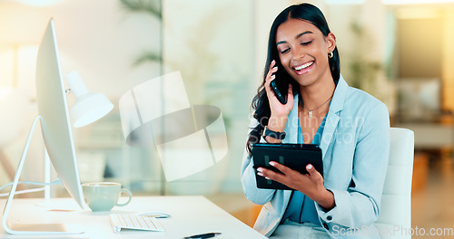 Image of Happy manager talking on a phone in modern office, booking appointment or arranging a meeting on tablet. Young, carefree professional female talking to a client while responding to emails