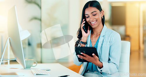 Image of Happy manager talking on a phone in modern office, booking appointment or arranging a meeting on tablet. Young, carefree professional female talking to a client while responding to emails