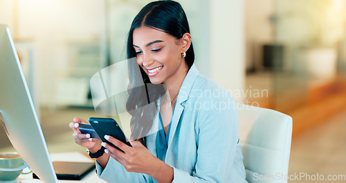 Image of Happy woman making online payment with phone and bank card for typing credit details into online banking app. Young business woman enjoying virtual shopping or wireless purchase while sitting inside