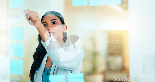 Image of A smart female entrepreneur planning the strategy of her company in the office. Young confident and successful business woman leader thinking and working on a project at the workplace