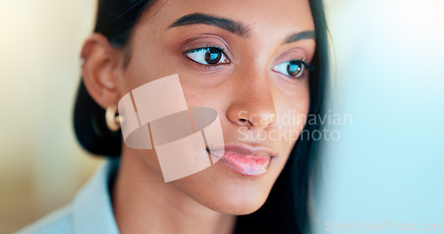 Image of Business woman reading information on a computer screen while working in an office. Closeup on face of one confident young entrepreneur and focused expert carefully analyzing ideas and plans online