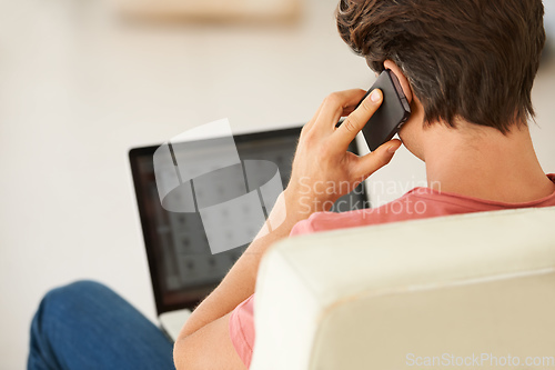 Image of Taking full advantage of the convenience that wireless technolog. Rear-view of a young man talking on his mobile while using his laptop.