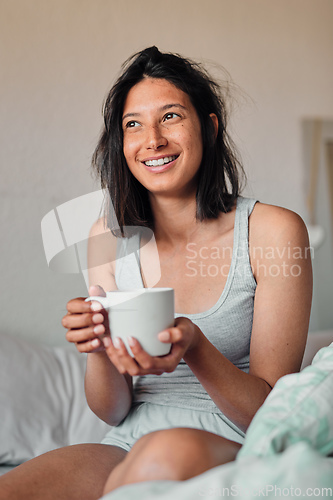 Image of I cant wait to see what this day will bring. Shot of a young woman enjoying a relaxing cup of coffee in bed at home.