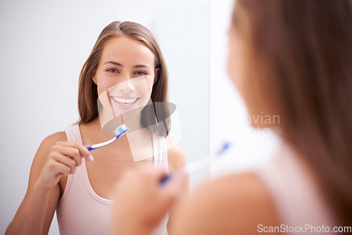 Image of Taking care of her smile. A young woman brushing her teeth.