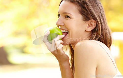 Image of Its more than just an apple.... Shot of an attractive young woman in the park on an autumn day.