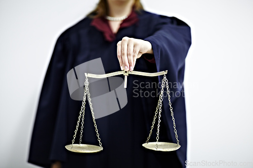 Image of The scales of justice. Conceptual image of a judge holding a scale.