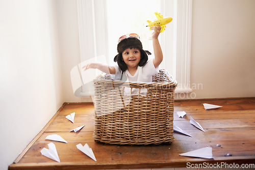 Image of Let your imagination take flight. A little boy playing with toy airplanes while sitting in a basket.