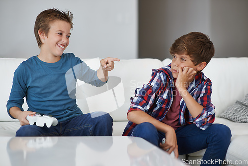 Image of Haha, you lost again. Shot of a young boy laughing at his friend after beating him at a video game.