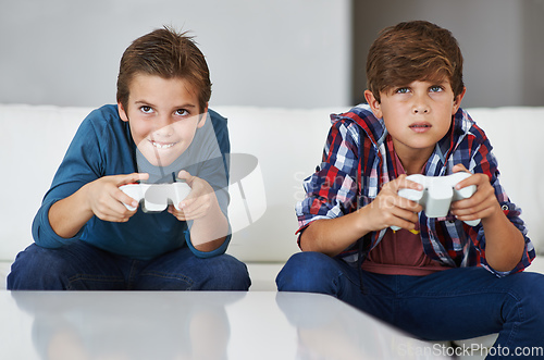 Image of Im gonna beat you. Shot of two young boys concentrating while playing video games.