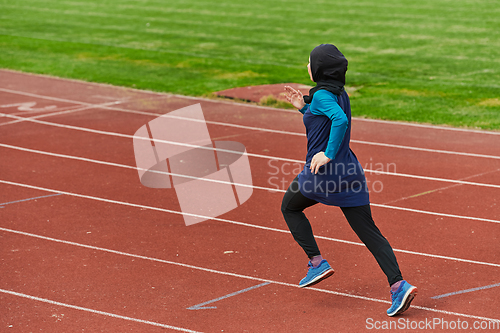 Image of A muslim woman in a burqa sports muslim clothes running on a marathon course and preparing for upcoming competitions