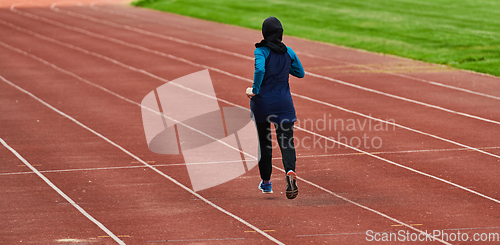 Image of A muslim woman in a burqa sports muslim clothes running on a marathon course and preparing for upcoming competitions