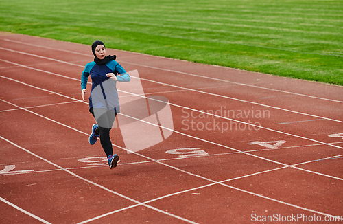 Image of A muslim woman in a burqa sports muslim clothes running on a marathon course and preparing for upcoming competitions