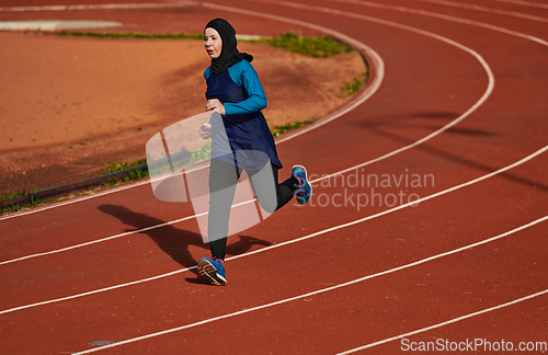 Image of A muslim woman in a burqa sports muslim clothes running on a marathon course and preparing for upcoming competitions