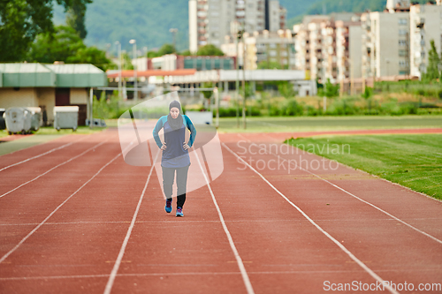 Image of A muslim woman in a burqa sports muslim clothes running on a marathon course and preparing for upcoming competitions