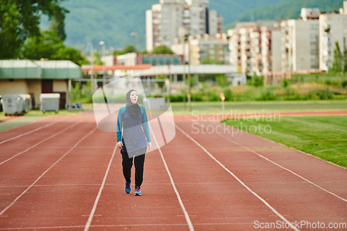 Image of A muslim woman in a burqa sports muslim clothes running on a marathon course and preparing for upcoming competitions