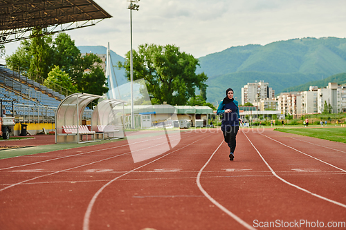 Image of A muslim woman in a burqa sports muslim clothes running on a marathon course and preparing for upcoming competitions