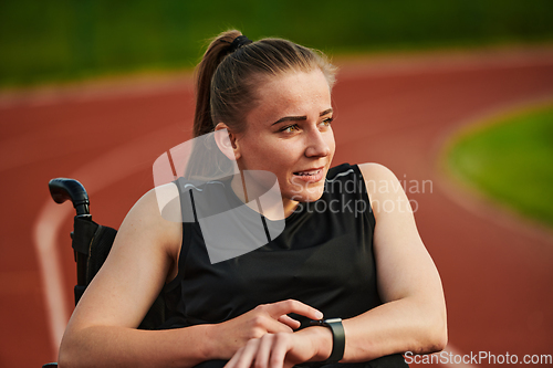 Image of A woman with disability in a wheelchair checking a smart watch after a quick workout