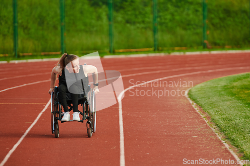 Image of A woman with disablity driving a wheelchair on a track while preparing for the Paralympic Games