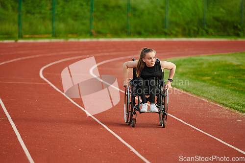 Image of A woman with disablity driving a wheelchair on a track while preparing for the Paralympic Games