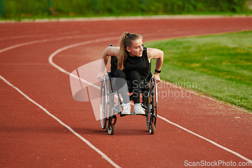 Image of A woman with disablity driving a wheelchair on a track while preparing for the Paralympic Games