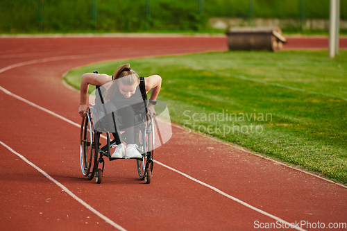 Image of A woman with disablity driving a wheelchair on a track while preparing for the Paralympic Games