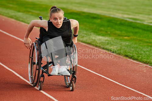 Image of A woman with disablity driving a wheelchair on a track while preparing for the Paralympic Games