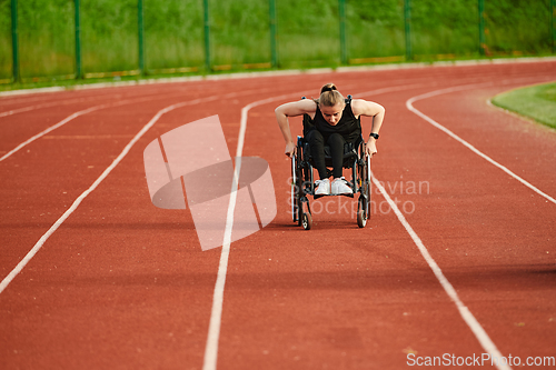 Image of A woman with disablity driving a wheelchair on a track while preparing for the Paralympic Games