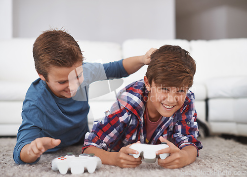 Image of You always beat me. Shot of two young boys teasing each other while playing video games.