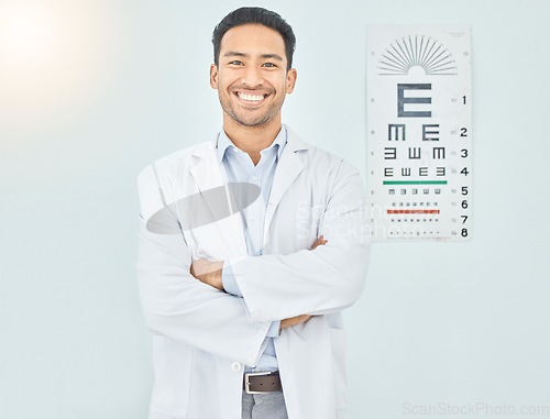 Image of Ophthalmologist, portrait and man with arms crossed in hospital mockup space for healthcare of vision. Face, confident optometrist and happy doctor, Asian optician or medical professional in Cambodia