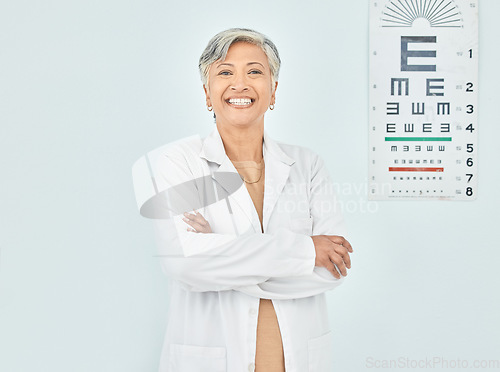 Image of Portrait, ophthalmologist and woman arms crossed in hospital mockup space for healthcare of vision. Face, confident optometrist and happy doctor, mature expert optician and physician smile in India