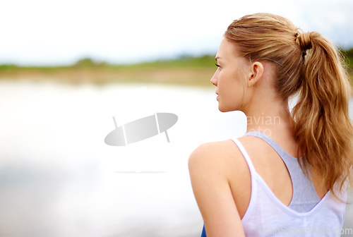 Image of Its all about finding the calm in the chaos. Rearview shot of a young woman sitting outdoors.