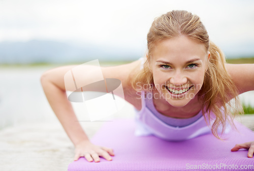 Image of Push yourself. Shot of a young woman doing yoga outdoors.