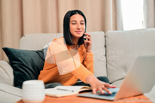 Image of Lifes short, spend it productively. Shot of a young woman using a laptop and smartphone while working on the sofa at home.