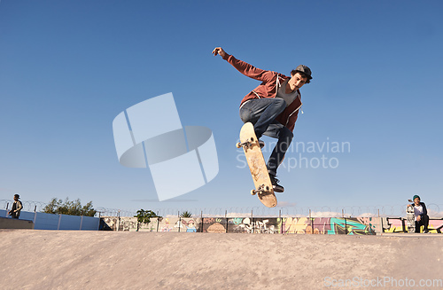 Image of Getting some air. A young man doing tricks on his skateboard at the skate park.