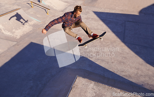 Image of A rad day at the skate park. A young man doing tricks on his skateboard at the skate park.