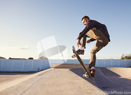 Image of A rad day at the skate park. A young man doing tricks on his skateboard at the skate park.