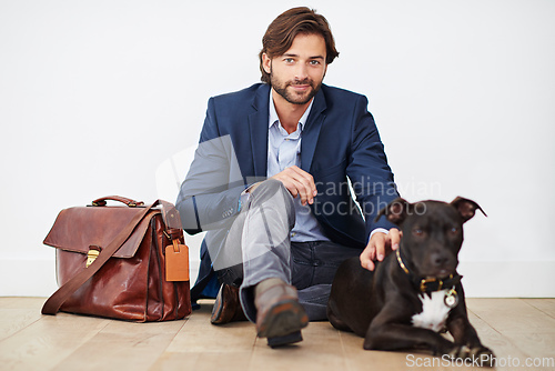 Image of Happiness is coming home to your dog. Shot of a handsome man spending time with his dog after a day at the office.